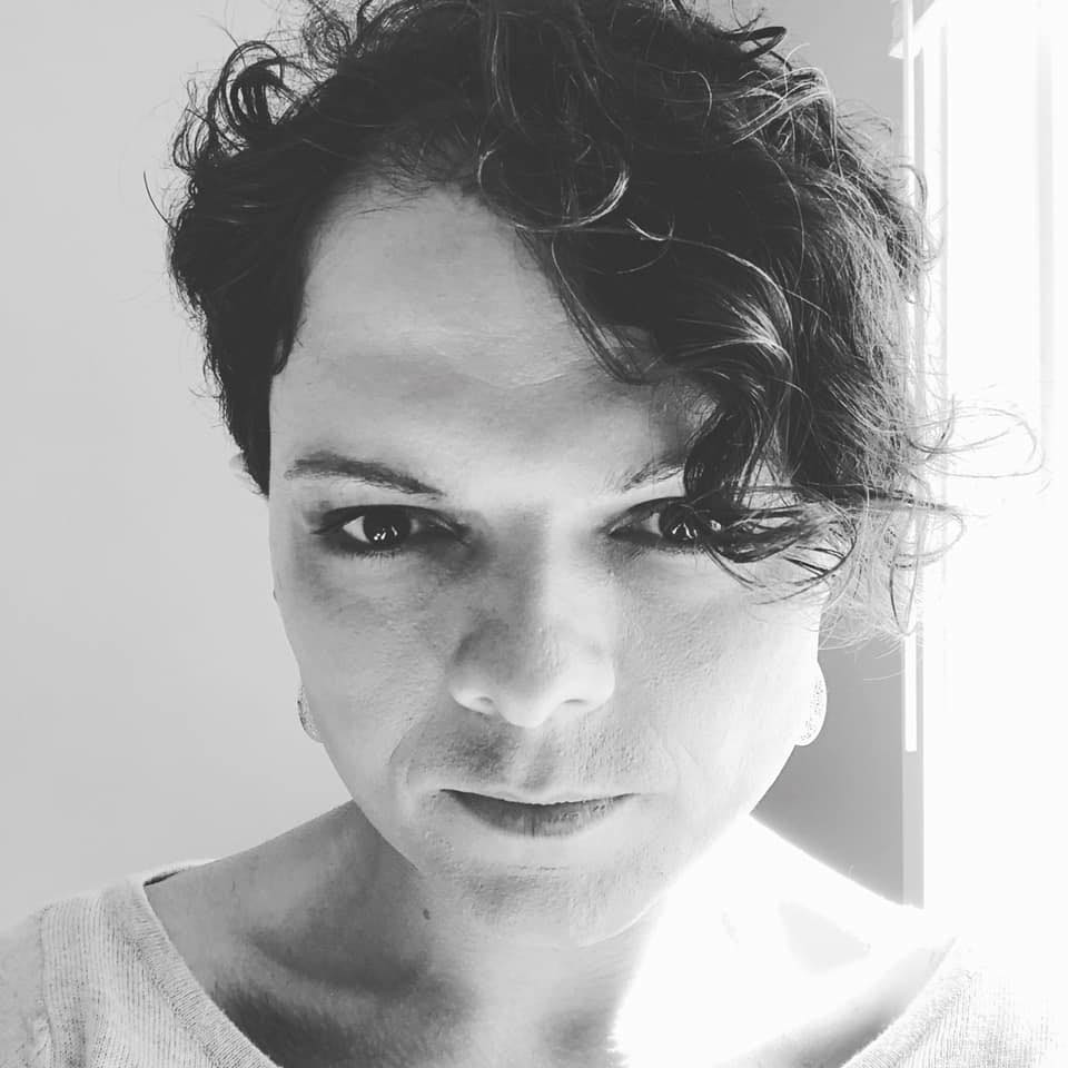 Black and white close-up of Sasha Fury beside a brightly lit window